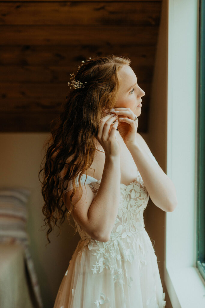 Bride putting earring on